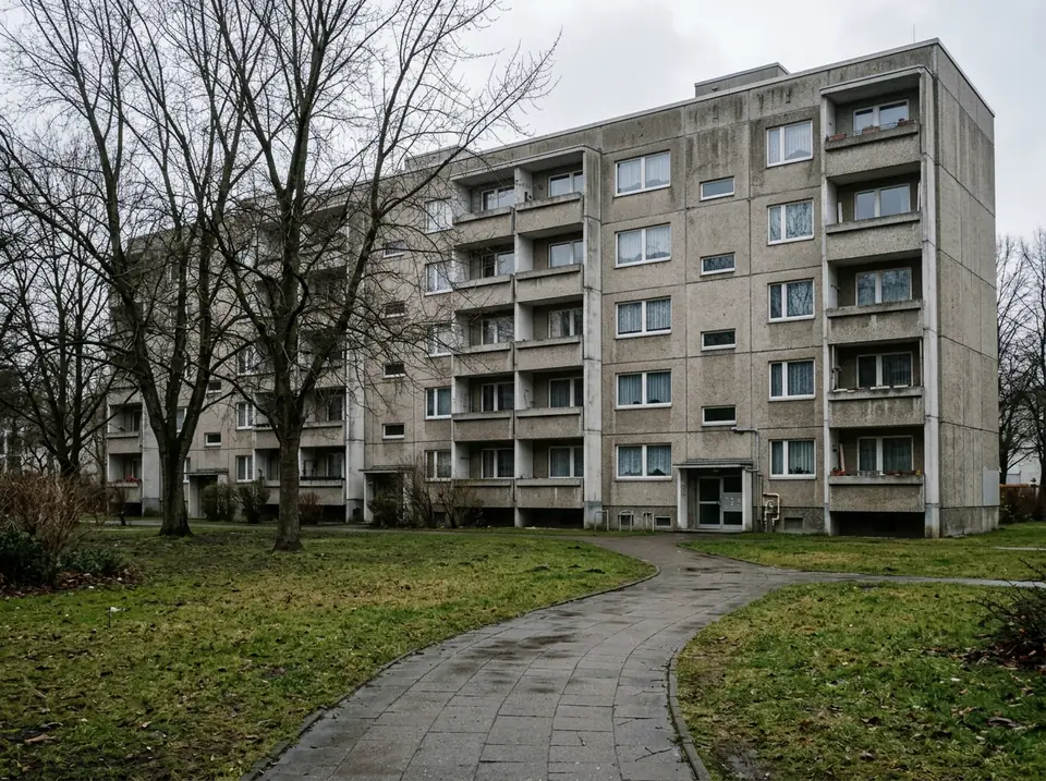 Panelházas lakótelep füves belső udvarral, borús időben